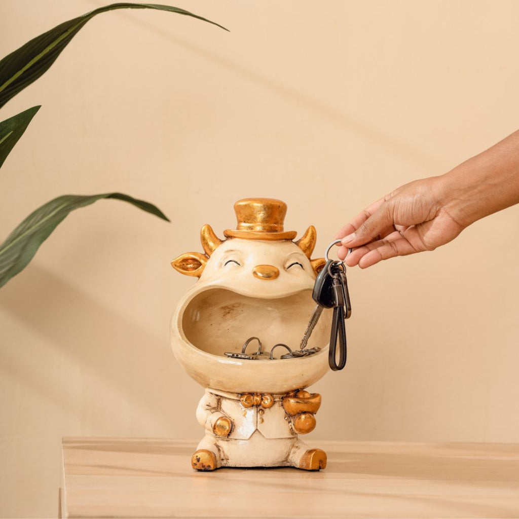 a hand is holding a key to a ceramic animal