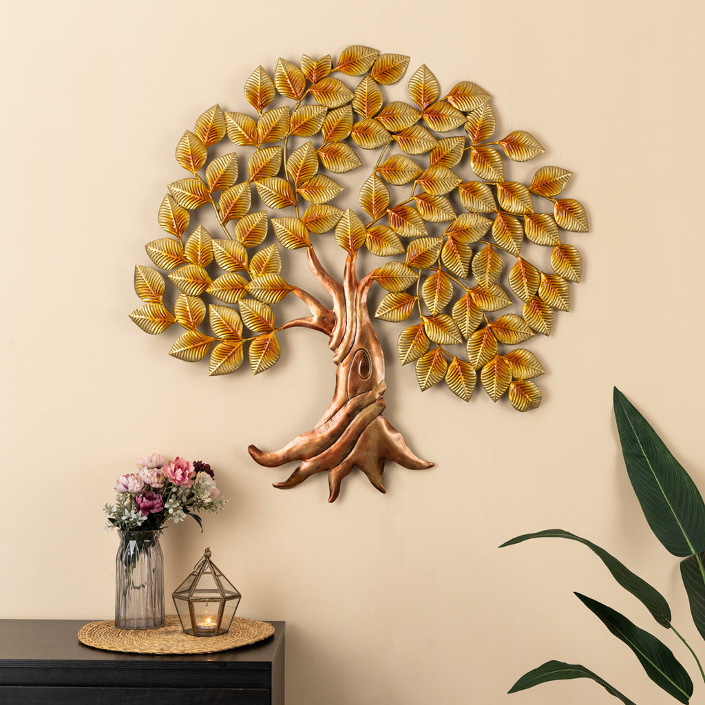 a metal tree with yellow leaves on a wall