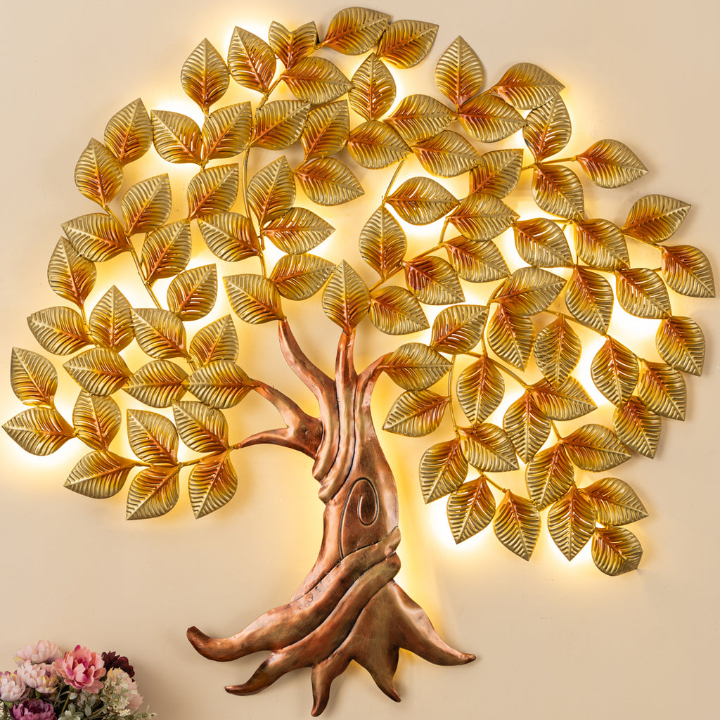 a metal tree with gold leaves on a white wall