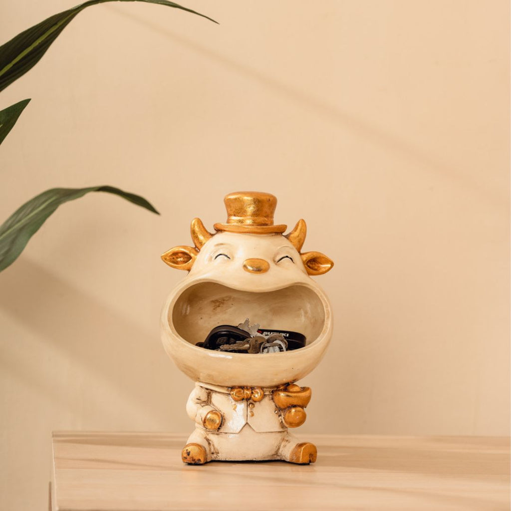 a ceramic cow with a top hat on a table
